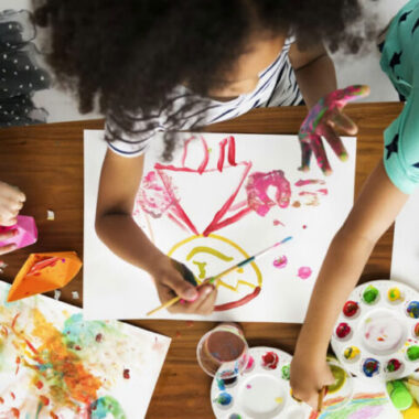 Grupo de niños dibujando y participando en una actividad creativa sobre una mesa